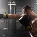 boxeador lanzando un puño con guantes de boxeo negros