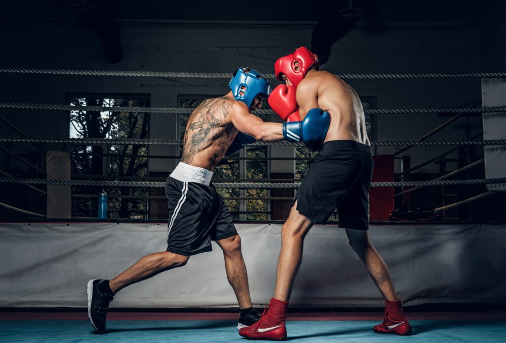 dos boxeadores musculosos compiten en el ring, llevan cascos y guantes. Errores comunes al empezar a entrenar boxeo