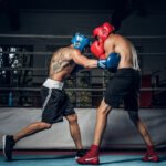 dos boxeadores musculosos compiten en el ring, llevan cascos y guantes