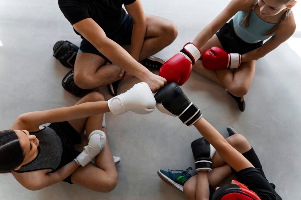 vista superior 4 niños chocando el puño en equipo en academia de boxeo
